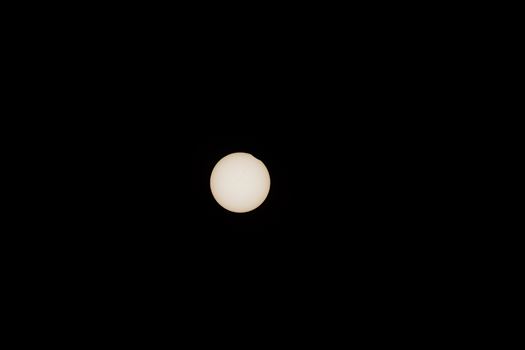 Lunar disk begins to cover the body of the sun above Carhenge, Alliance, Nebraska. 
